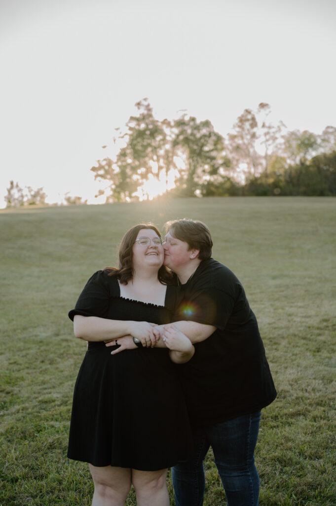 Couple hugging through a golden field in Cuyahoga Valley National Park during sunset